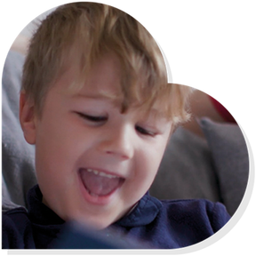 A boy smiles while reading a book