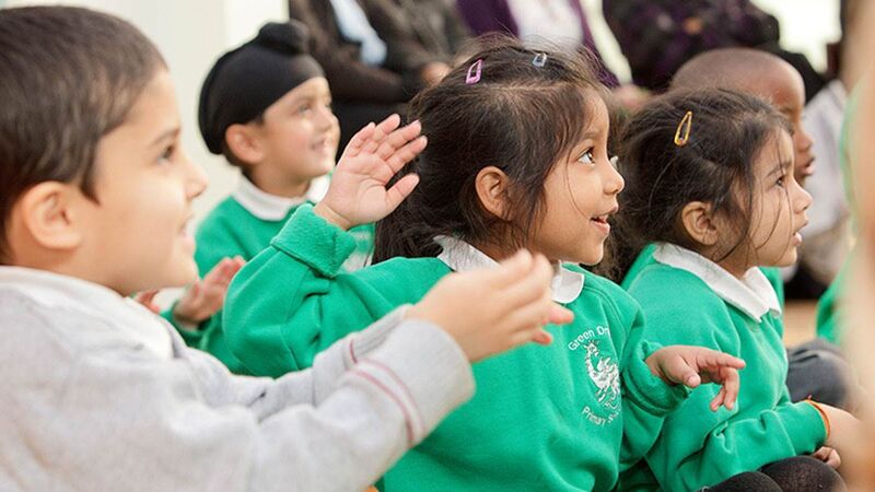 Children at school listening to a teacher.