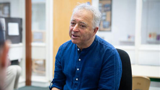 Frank Cottrell-Boyce smiling and speaking to someone