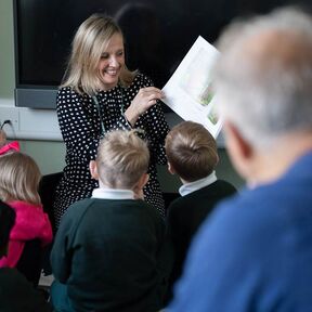 Frank Cottrell-Boyce watching a woman reading The Gruffalo to a group of children