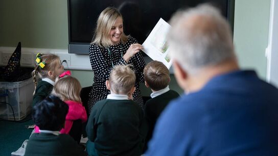 Frank Cottrell-Boyce watching a woman reading The Gruffalo to a group of children