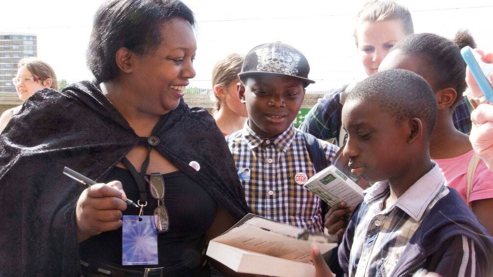 Malorie Blackman signing copies of her book for a group of teenagers