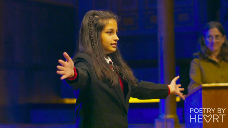 A child stretching out their arms on stage