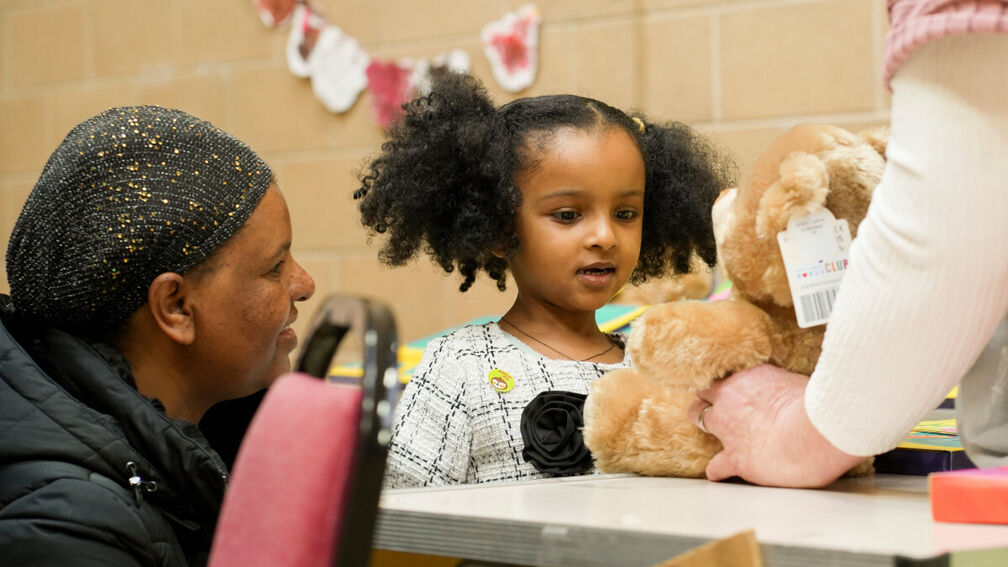 A photo of a child being given their own Build-A-Bear