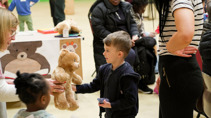 A photo of a child being given their own Build-A-Bear