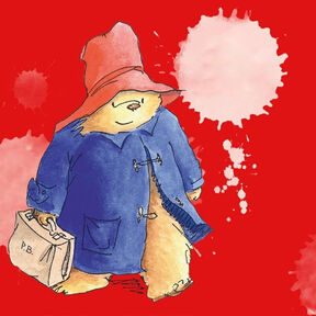 An illustration from the front cover of A Bear Called Paddington: a bear in a duffel coat and hat holding a suitcase and smiling