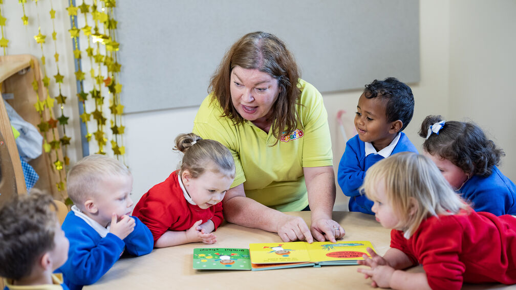 person reading a book to school children