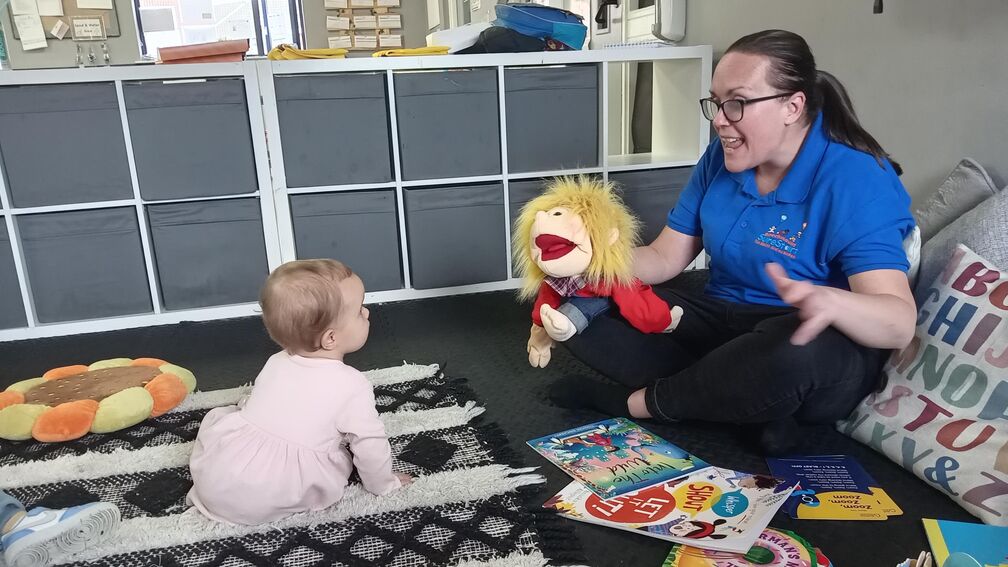 Person sitting on a floor with a baby