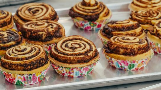 swirly brown cup cakes on a metal tray