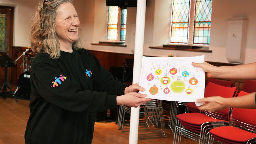 A woman giving out one of the Christmas packs