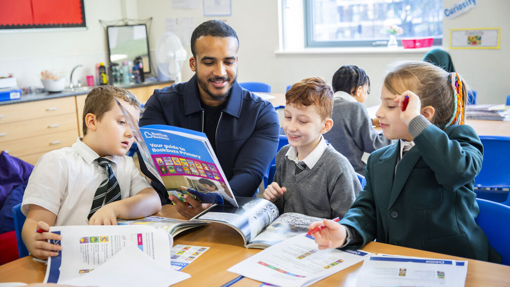 teacher and children looking at Bookbuzz Primary brochure