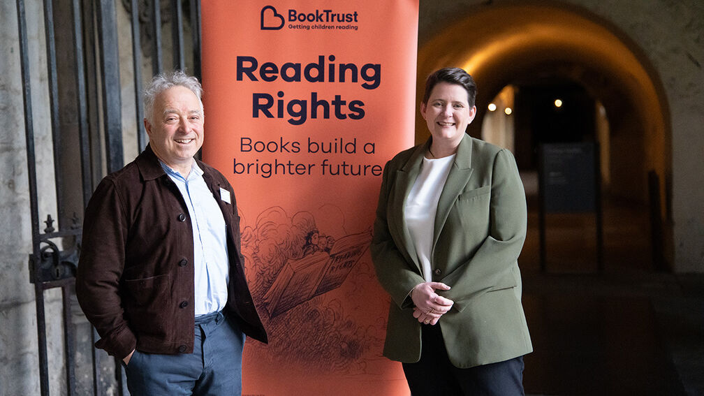 Frank Cottrell-Boyce and Olivia Bailey MP standing either side of a Reading Rights banner in Westminster Abbey