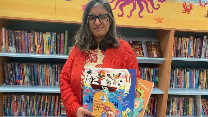 Librarian holding BookTrust Storytime books and resources