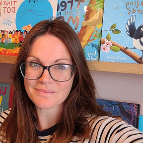 Lucy Rowland smiling in front of bookshelves