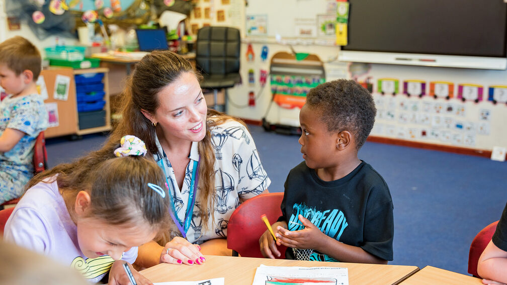 A teacher supporting children in the classroom.