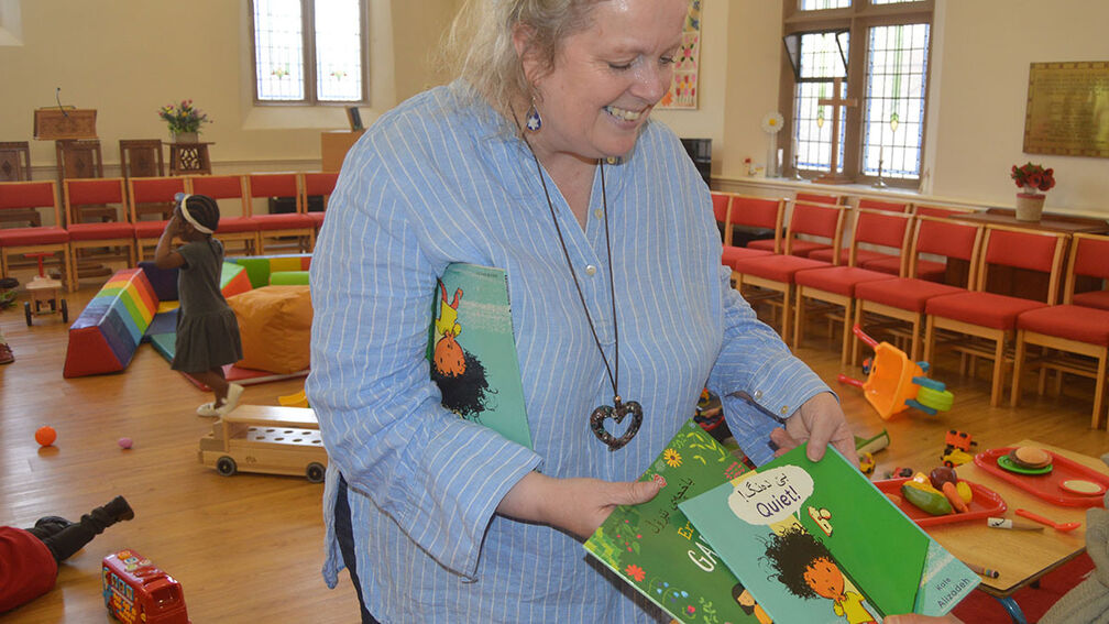 A lady holding out a booktrust pack.