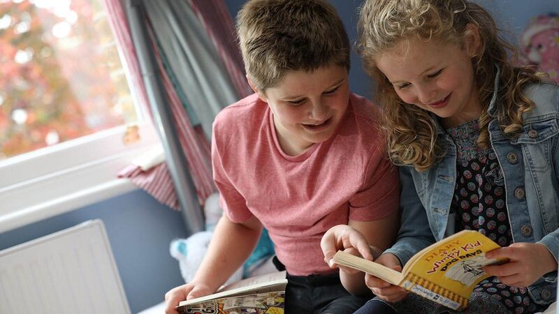 Two children reading together indoors