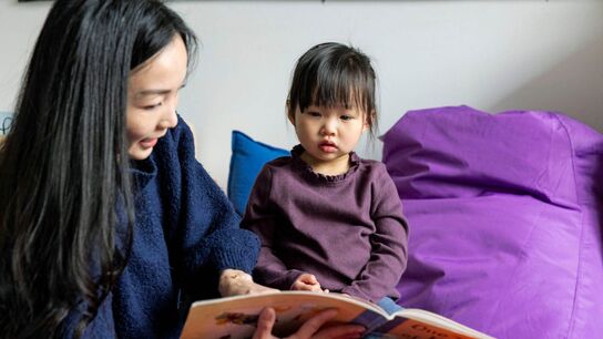 A mother reading to her child at home.