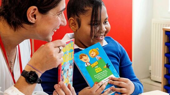 A teacher and a child enjoying Letterbox Club books