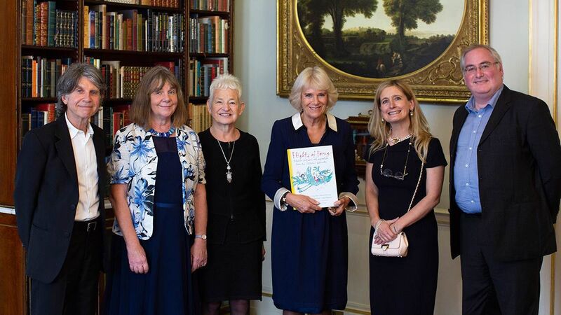 Her Majesty attending a celebratory tea with other attendees.