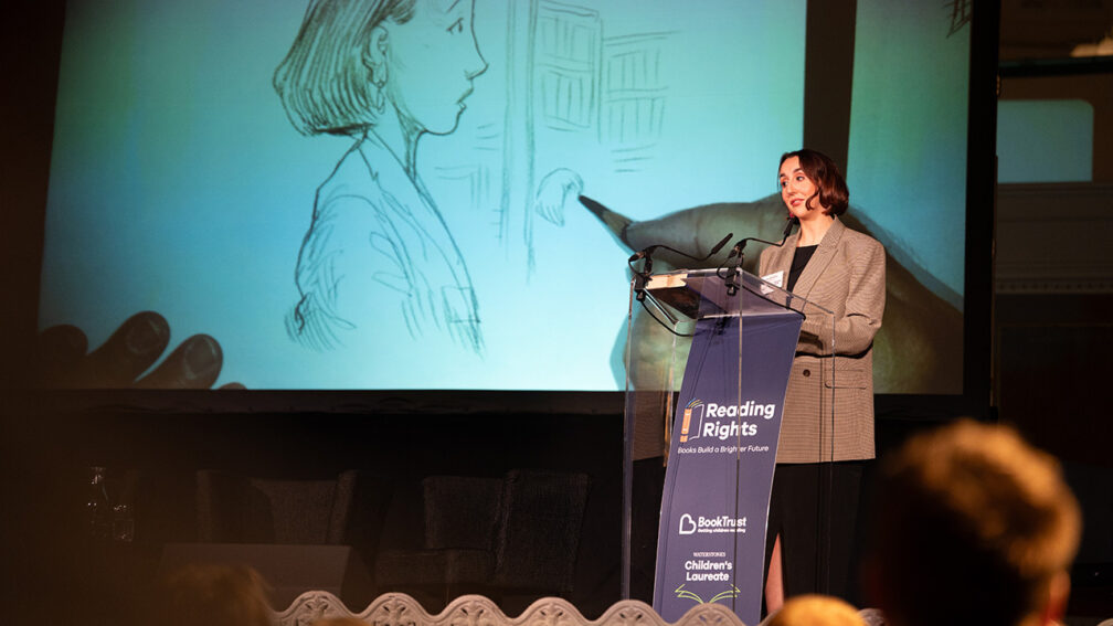 Alex McCormick speaking on stage at the Reading Rights summit